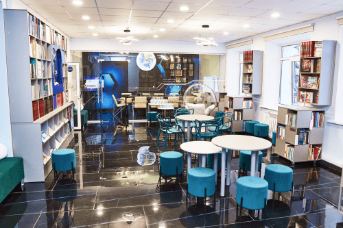 Пространство модельной библиотеки с детьми и книжными стеллажами